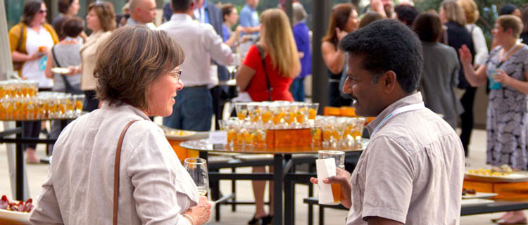 Two people chat during the Welcome Reception on the Luskin Center's Centennial Terrace